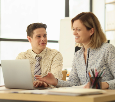 happy-colleagues-sit-wooden-table-looking-laptop-together-young-man-woman-formal