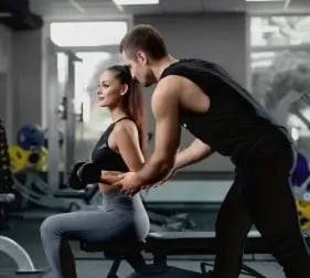 handsome-personal-instructor-helping-his-female-client-training-with-dumbbells (1)
